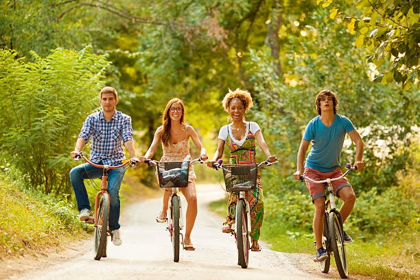 Visuel de 4 personnes à vélo côte à côte sur la route ne portant pas de casque de protection